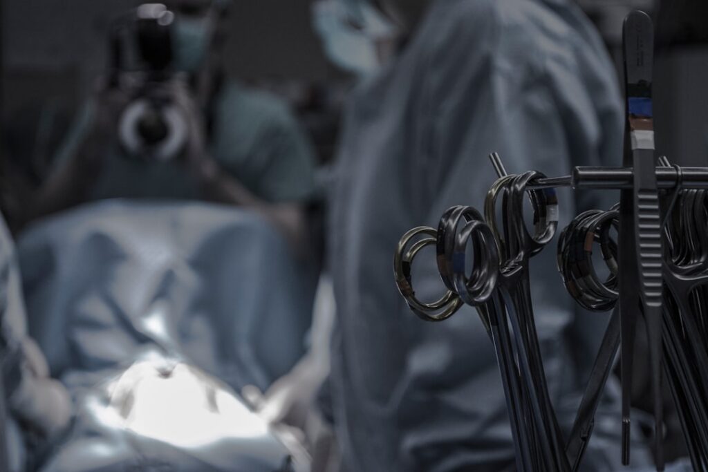 gray surgical scissors near doctors in operating room
