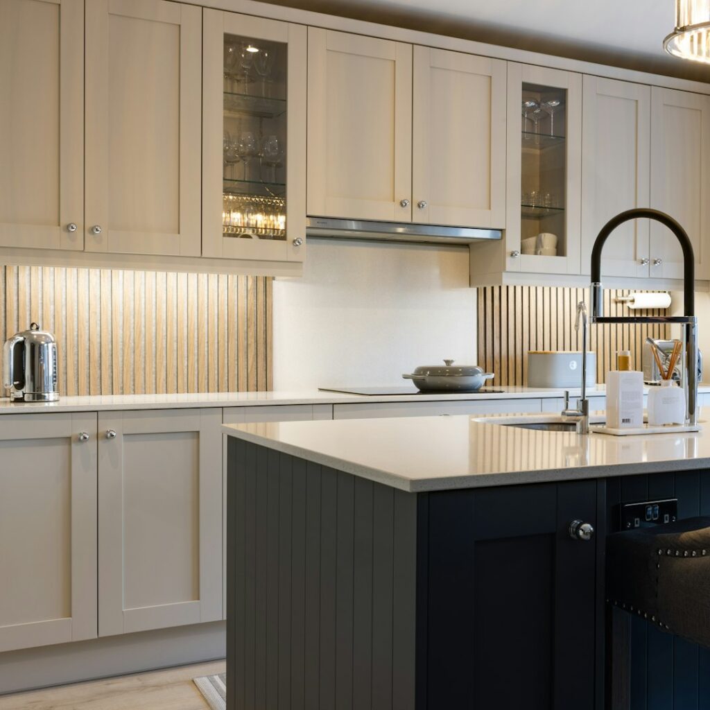 a kitchen with white cabinets and a black island